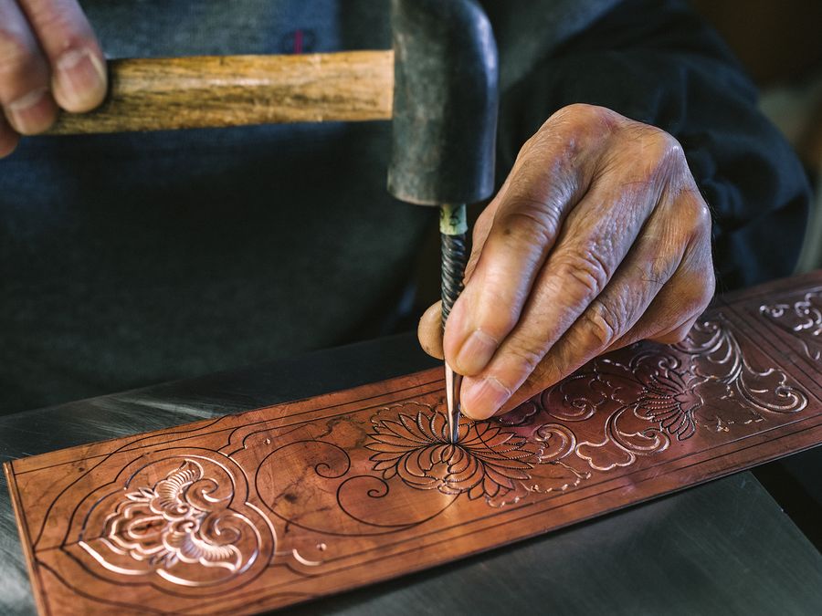 銅板に彫金をほどこす職人の手元